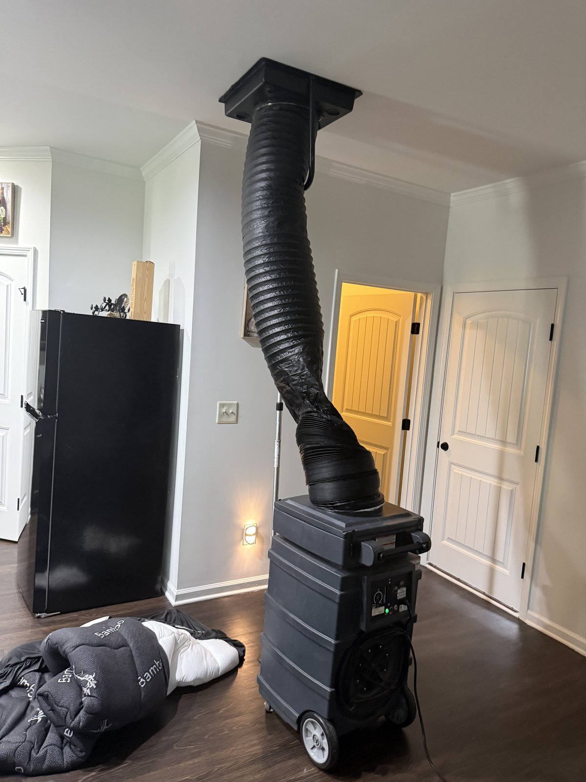 Negative-pressure air duct cleaning machine connected to a ceiling register on a Metro Atlanta job